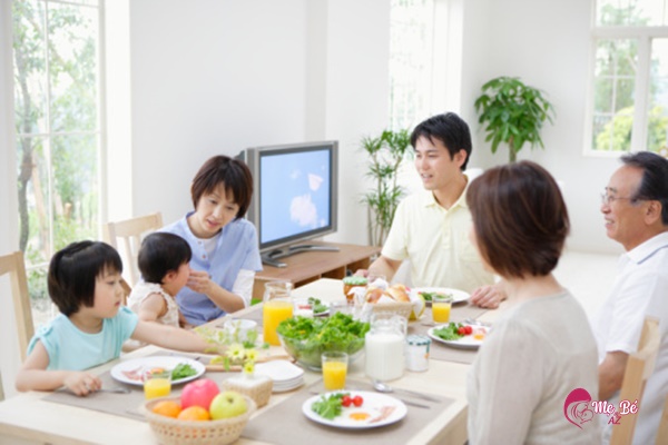 Bé ăn cơm cùng gia đình